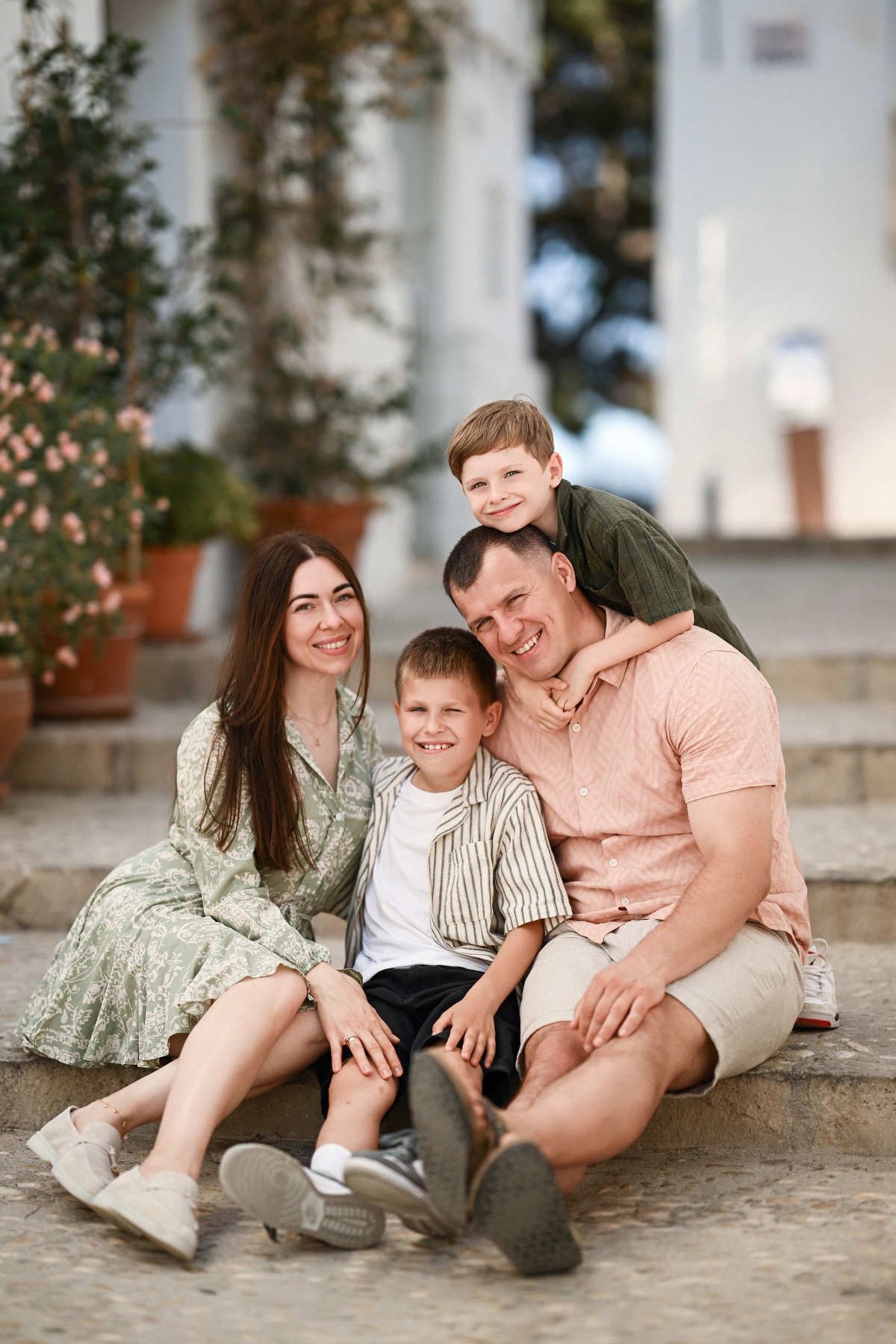 Authentic family portrait sitting together on the steps in the car-free, aesthetic Old Town of Altea, Costa Blanca.