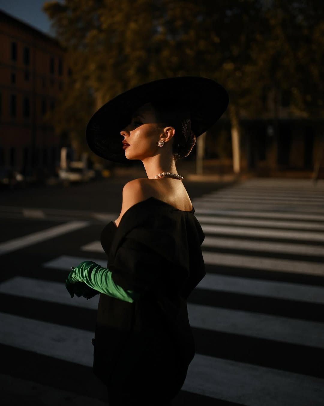 A model with professional styling and makeup posing at a crosswalk, highlighting a high-fashion look from our expert team.