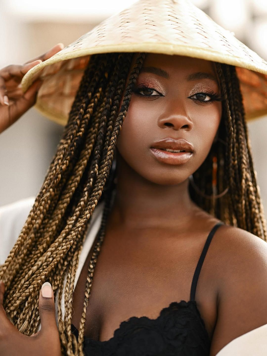 Creative portrait of a woman wearing a woven conical hat while sitting inside a rustic boat at Albufera Valencia