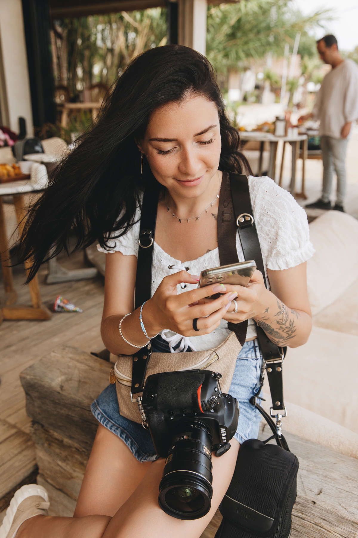 Backstage shot of professional portrait photographer Darina Derzkaya reviewing images on her smartphone on a shoot location.