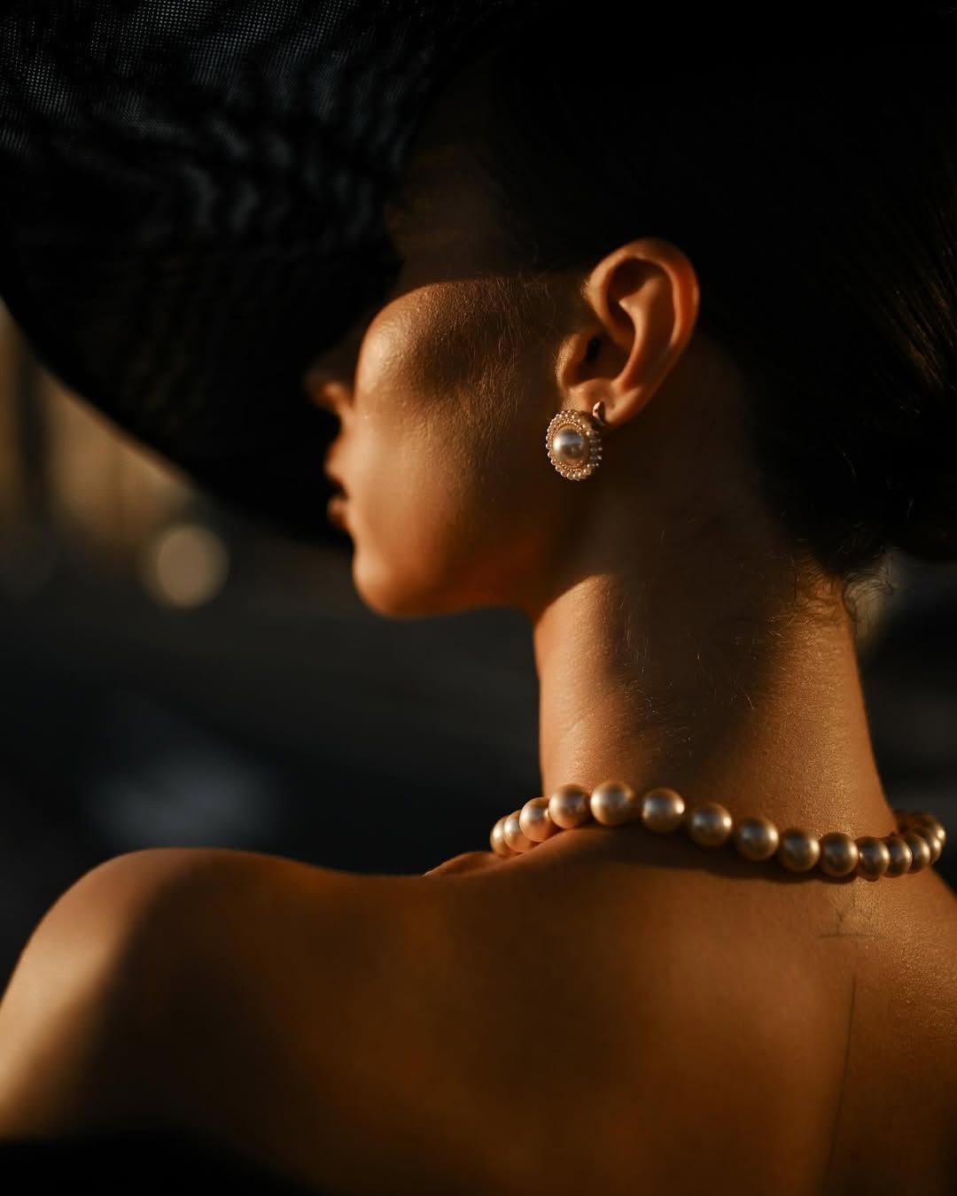 A back view of an elegantly styled model with professional makeup, part of a curated high-fashion photography experience.