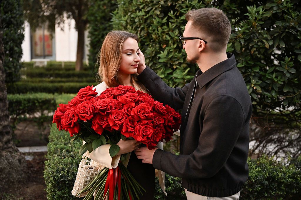 Romantic couple with red roses and candles during a Valentine's Day couples session in Valencia