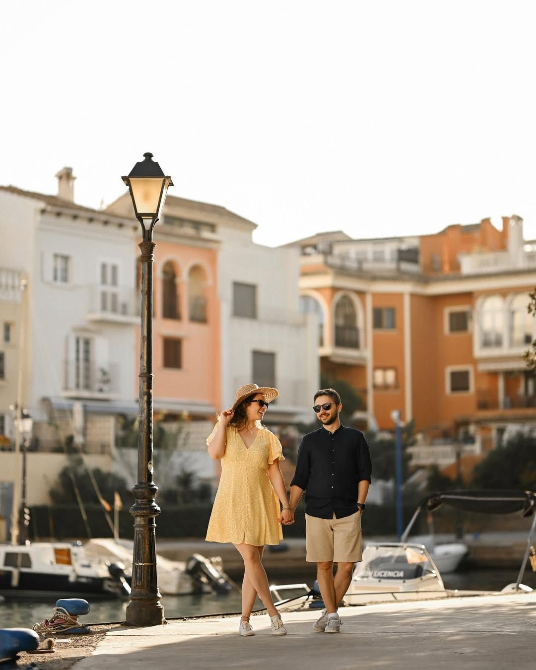 Cinematic portrait of a couple walking along the pedestrian streets and colorful facades of the Port Saplaya marina