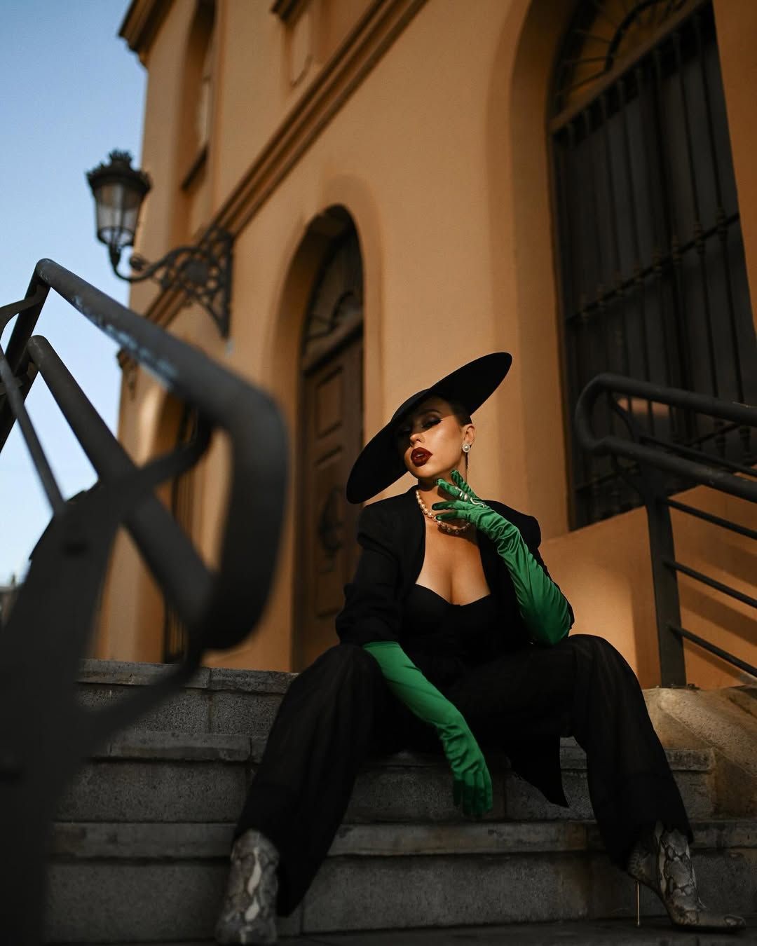 A model sitting on city stairs with professional styling and makeup, perfectly curated for a high-end fashion photoshoot.