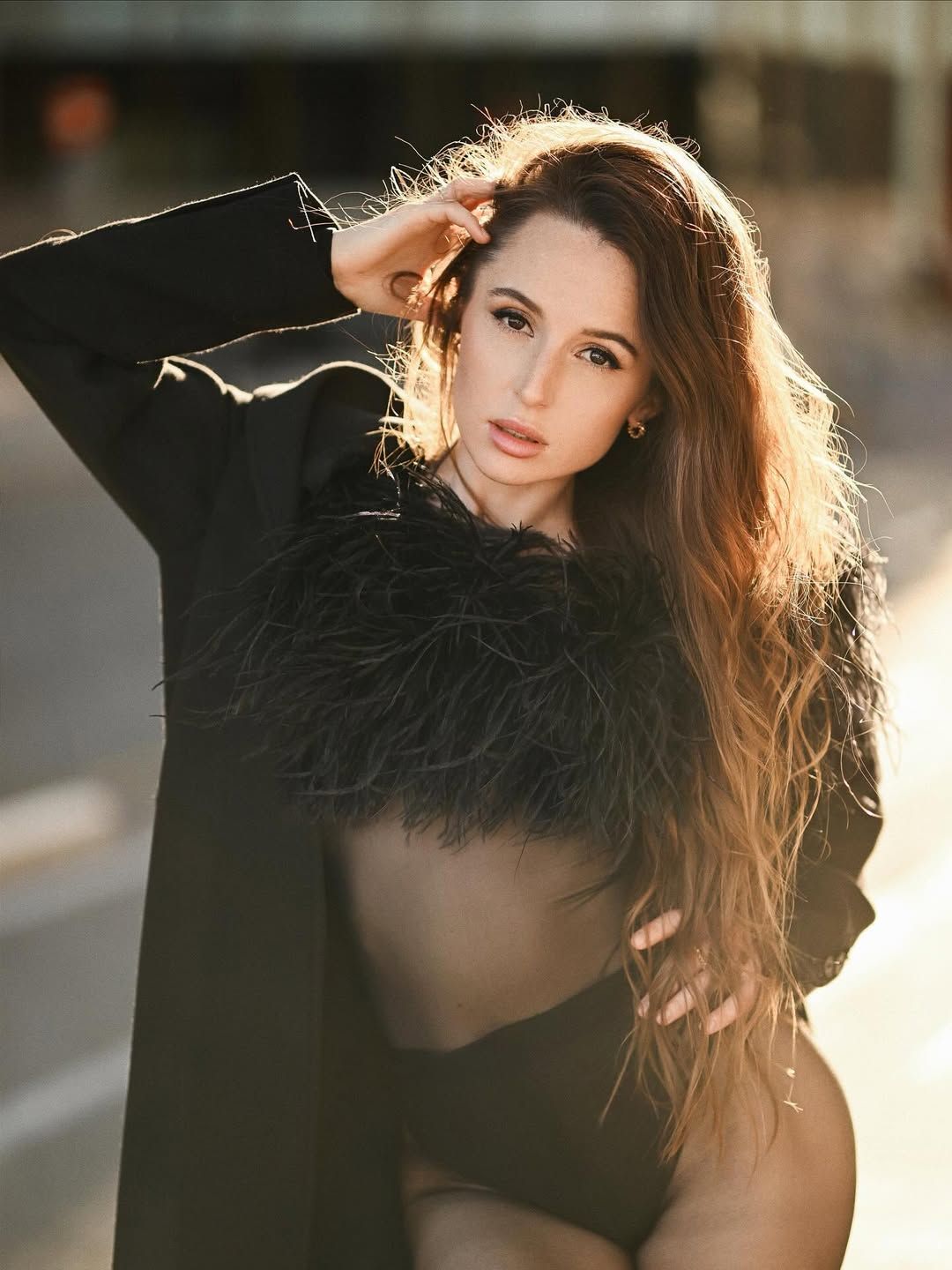 A cinematic fashion portrait of a model with flowing hair posing in the golden hour light on a street in historic Valencia.