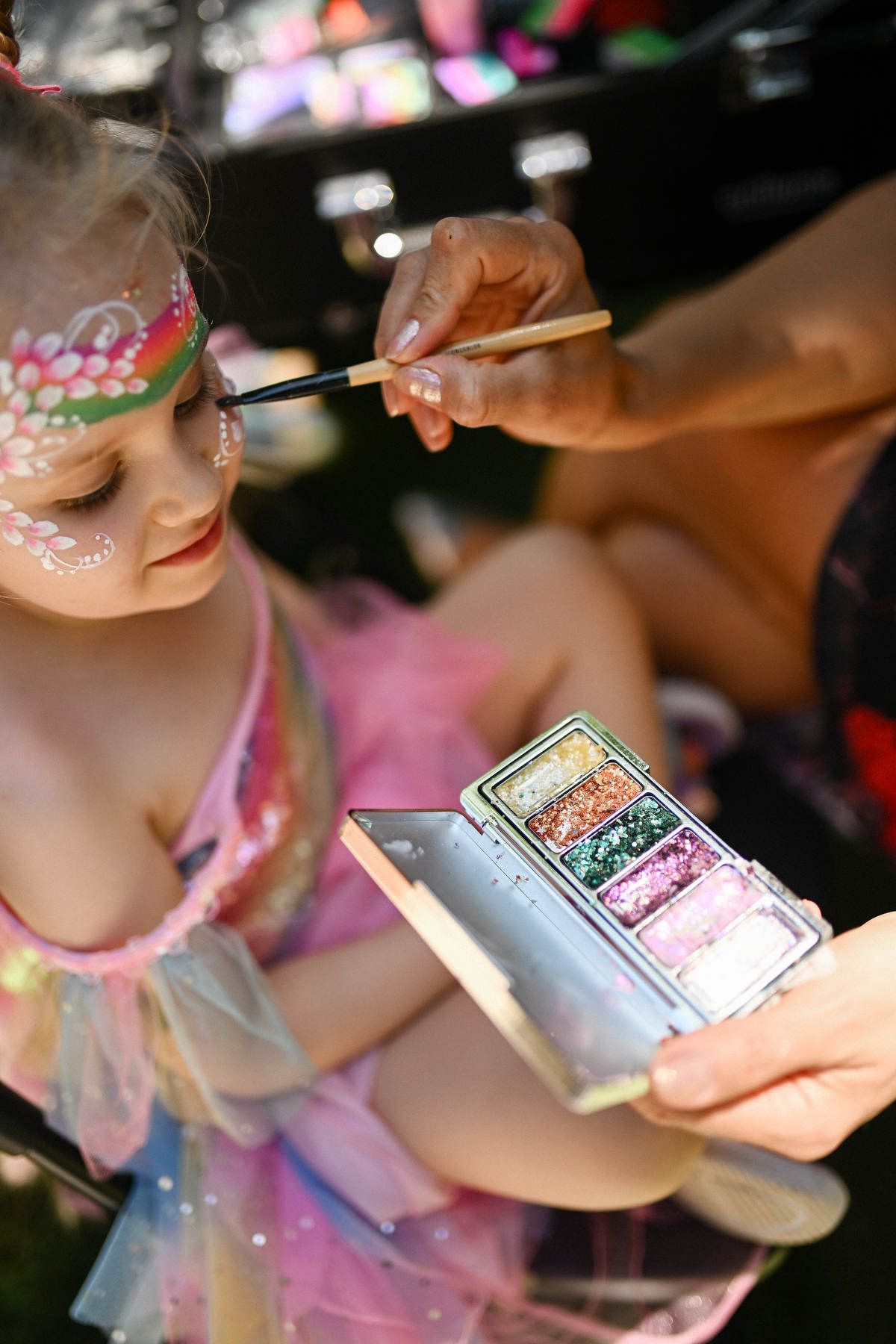 young girl who has a colorful rainbow unicorn face paint design.
