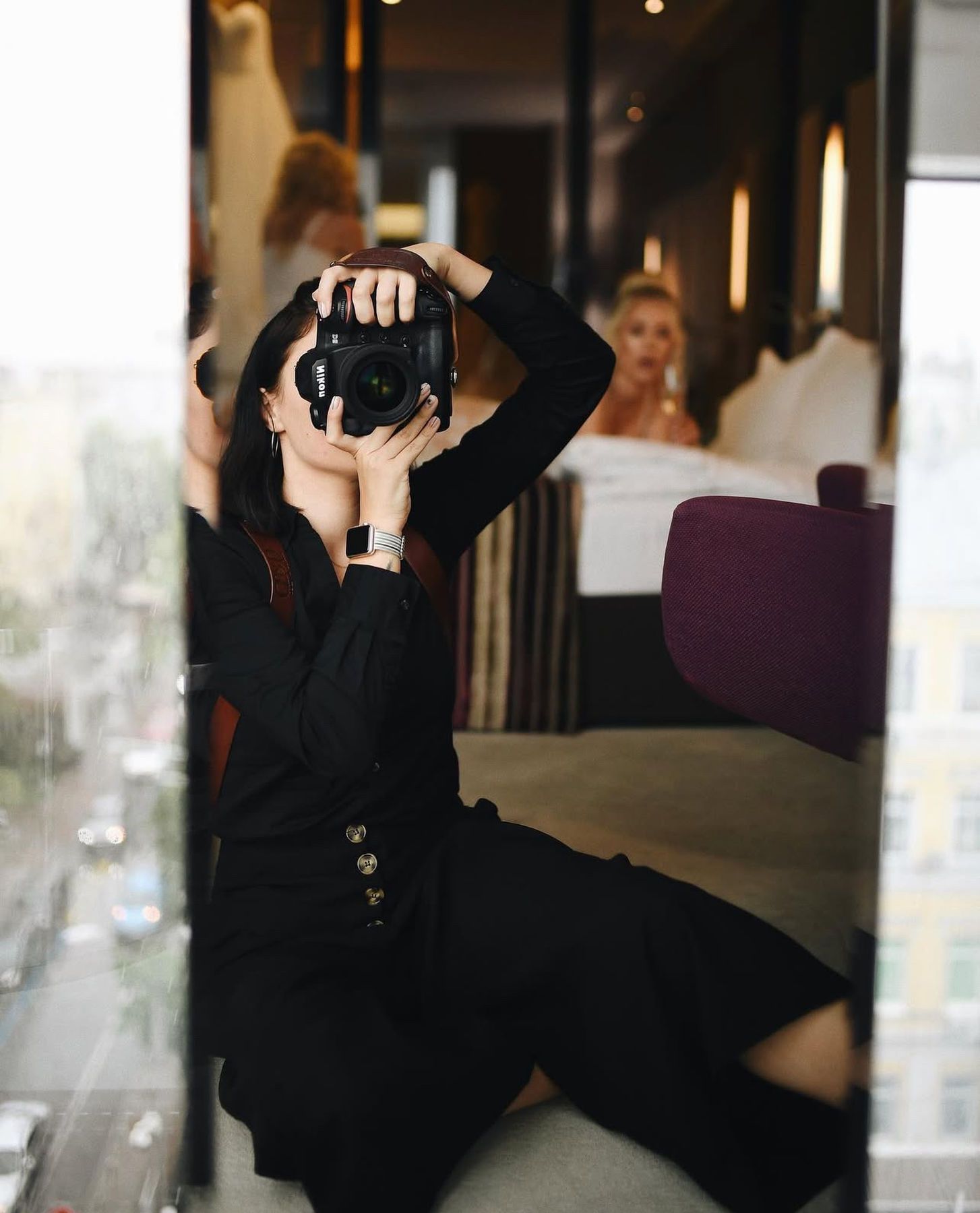 Photographer Darina Derzkaya taking a mirror selfie while working backstage at an editorial wedding session in Valencia.