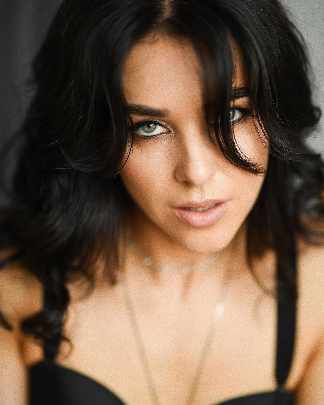 Close-up intimate women's portrait by Darina Derzkaya. Elegant boudoir photography focusing on natural beauty and soft studio lighting.