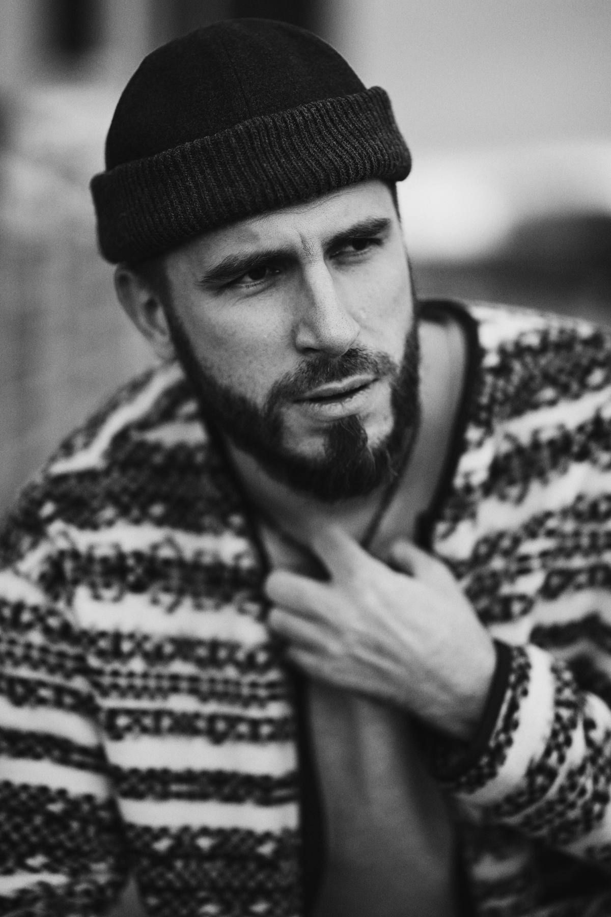 Candid, masculine portrait of a man on the streets of Valencia, showcasing a rugged lifestyle style look for social media.