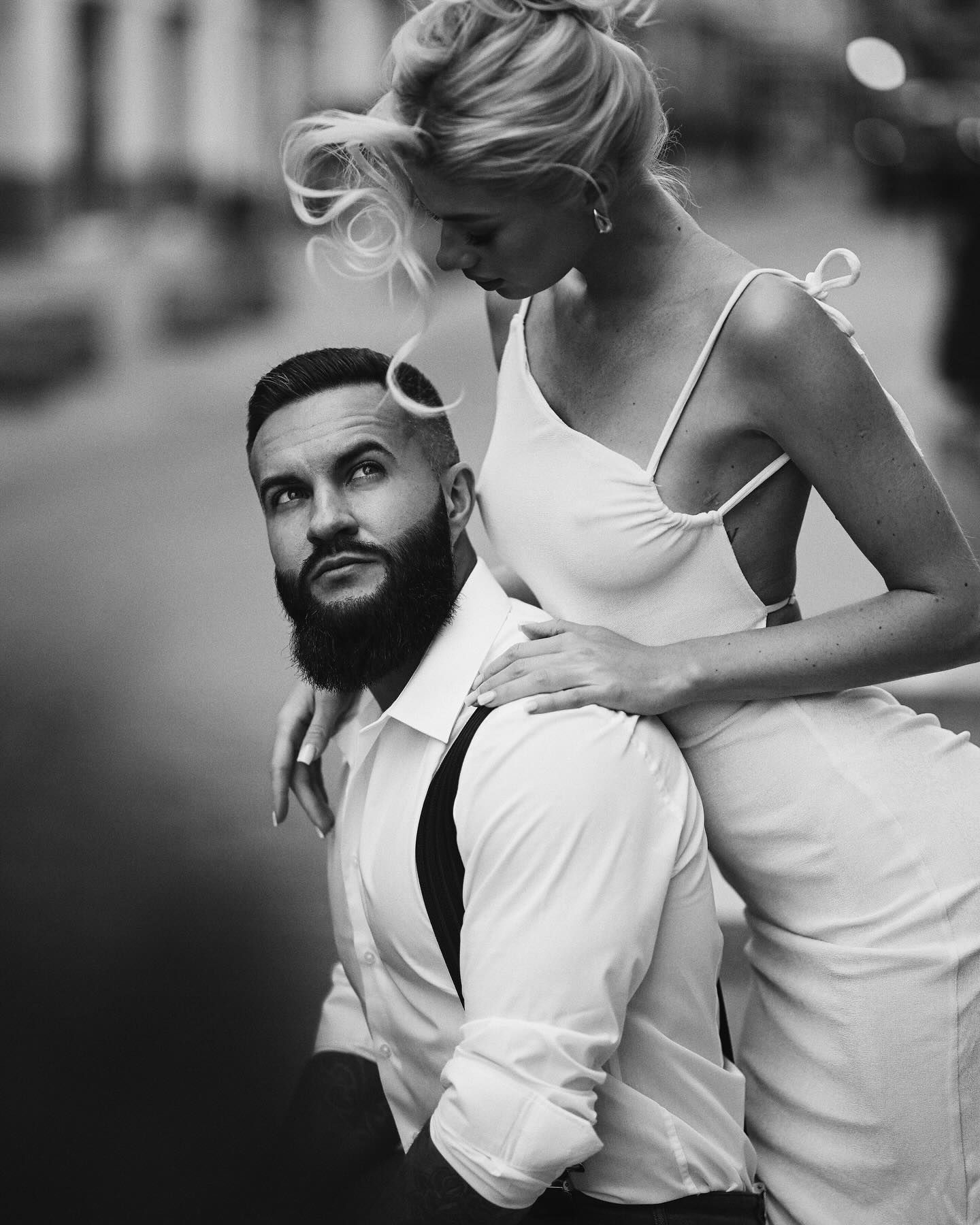 A soulful black and white portrait of a bride leaning over her groom's shoulder during a cinematic wedding photoshoot in Valencia.