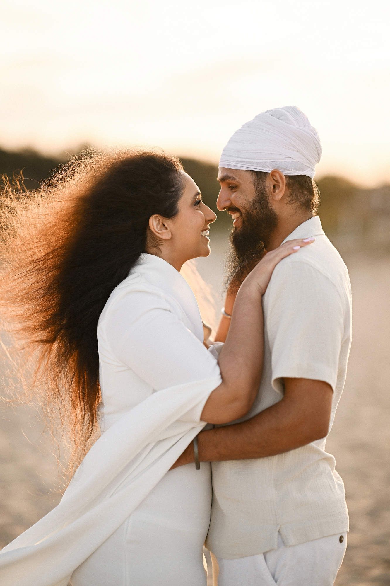 A romantic sunset embrace between a couple on a Valencia beach immediately after a successful marriage proposal session.