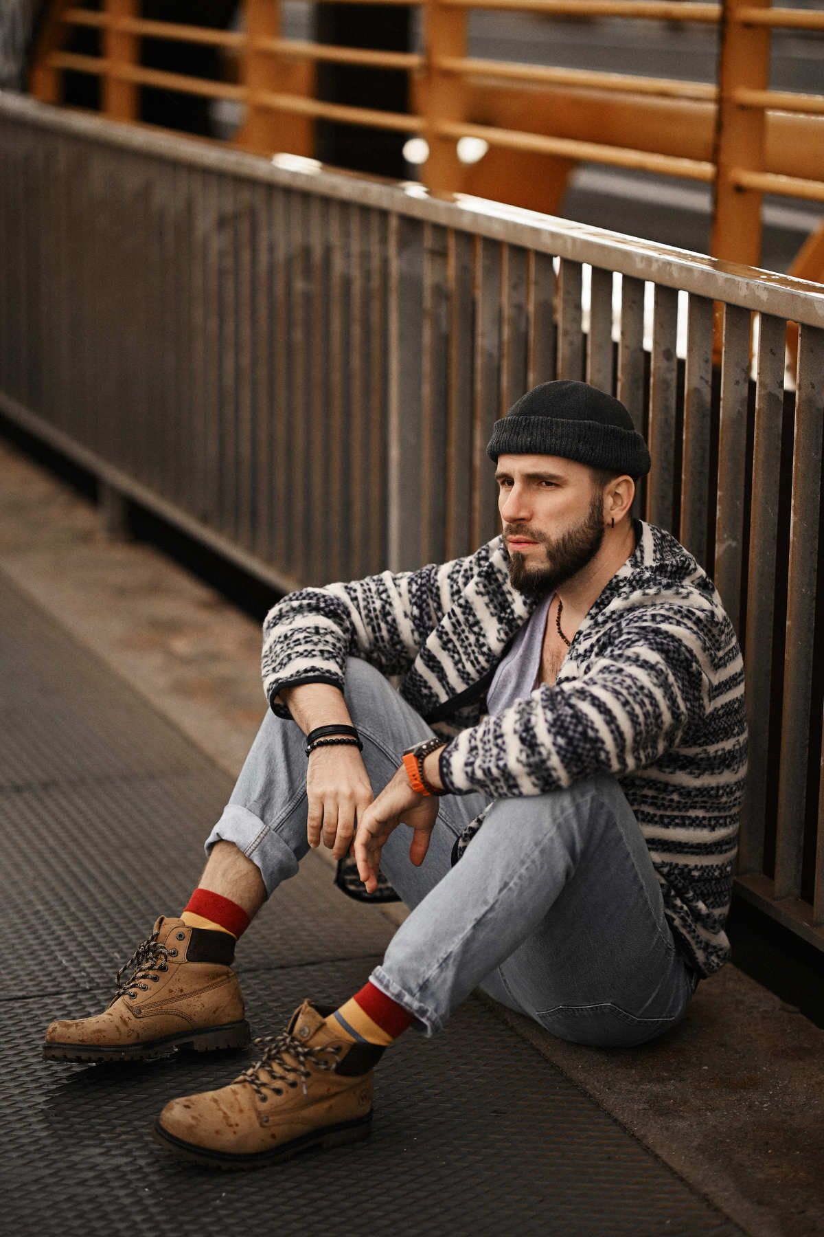 Cinematic portrait of a man sitting on a bridge in Valencia and looking into the distance, cinematic lifestyle shoot.