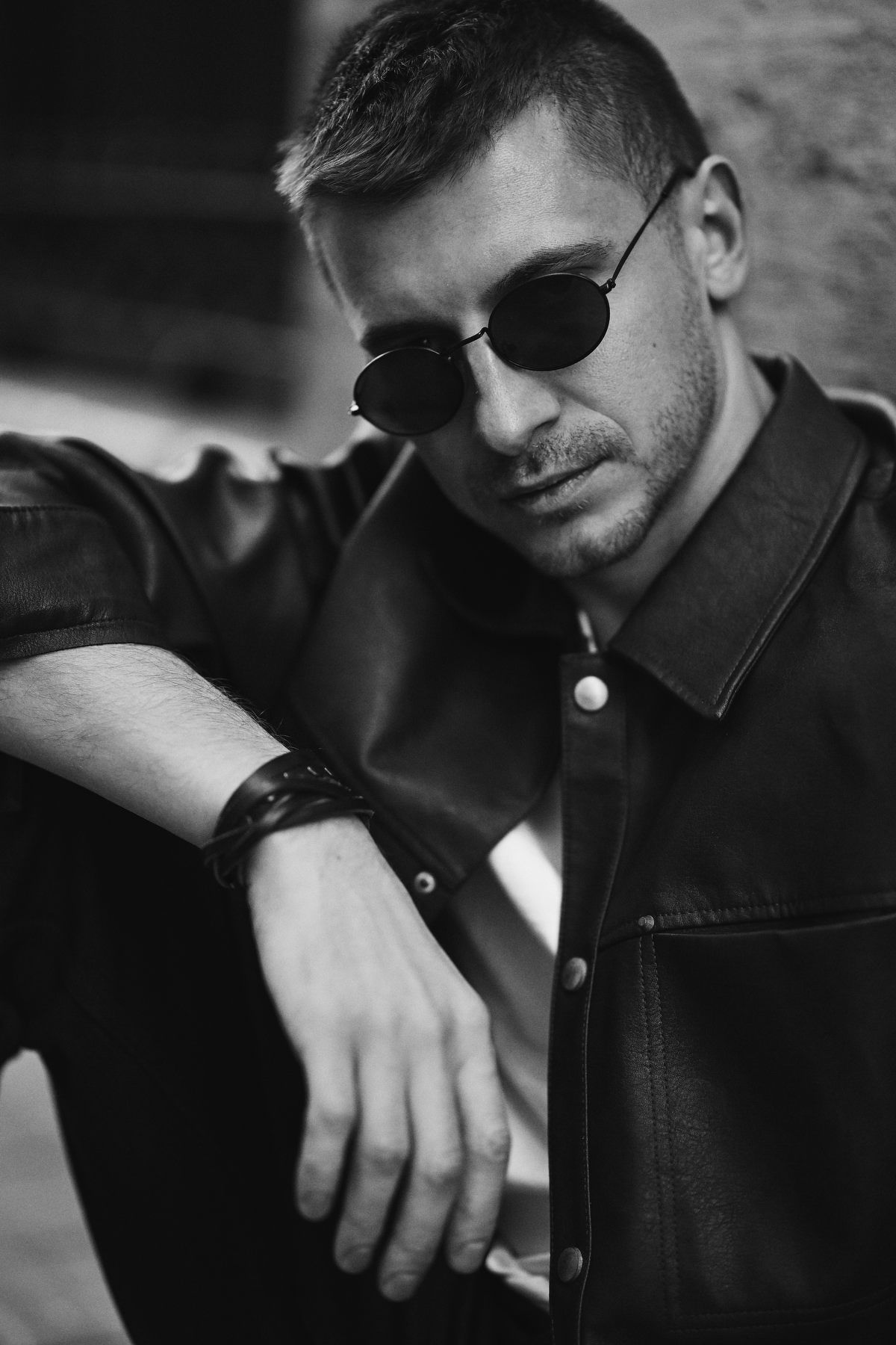 Close-up portrait of a confident man wearing sunglasses and looking into the lens on the sunny streets of Valencia.