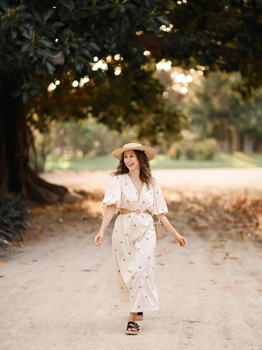 A happy, laughing woman walking down a dirt path in a scenic garden, creating a perfect candid shot for a social media profile.