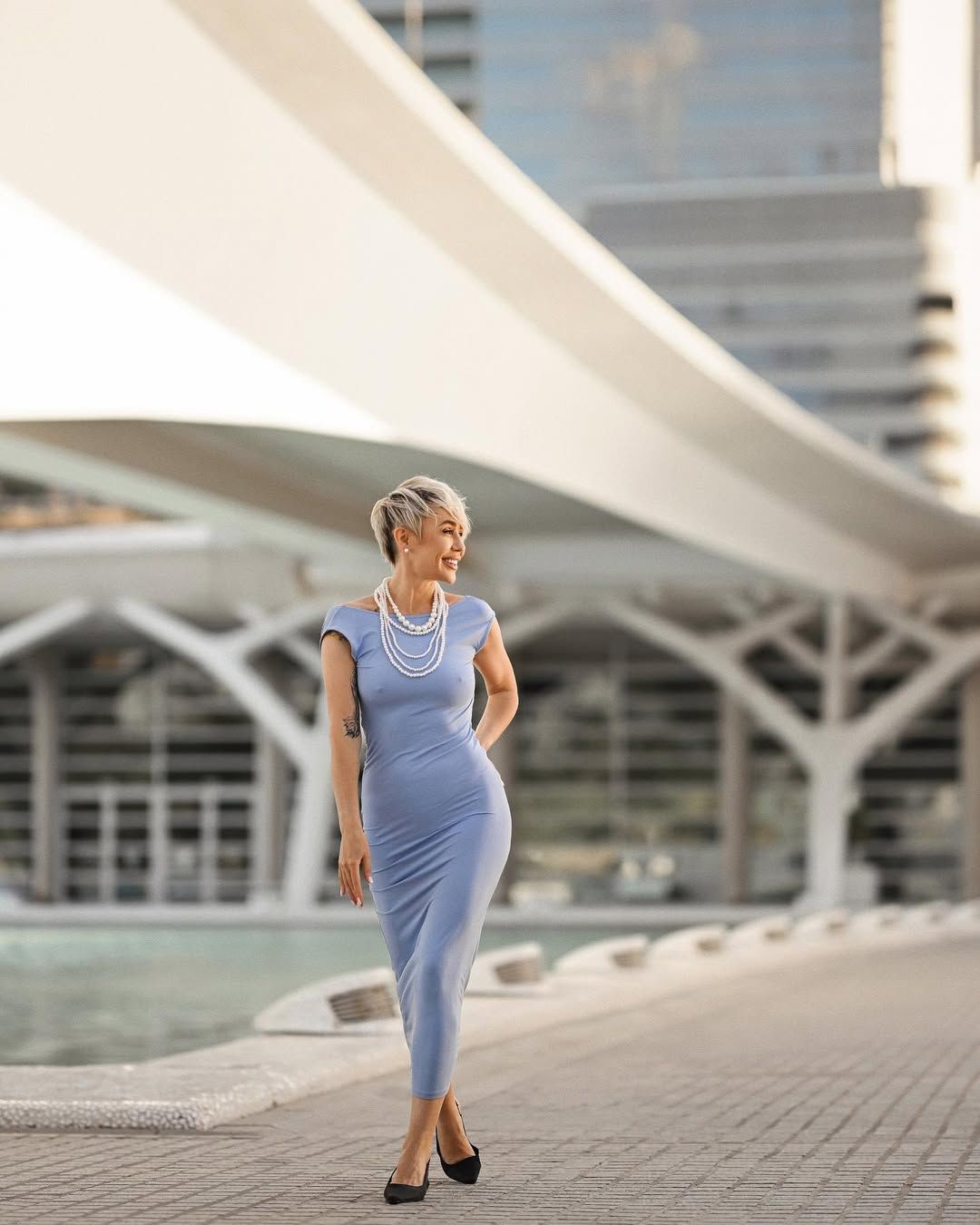 A woman walks like a model through the iconic geometric pathways of the Ciudad de las Artes y las Ciencias