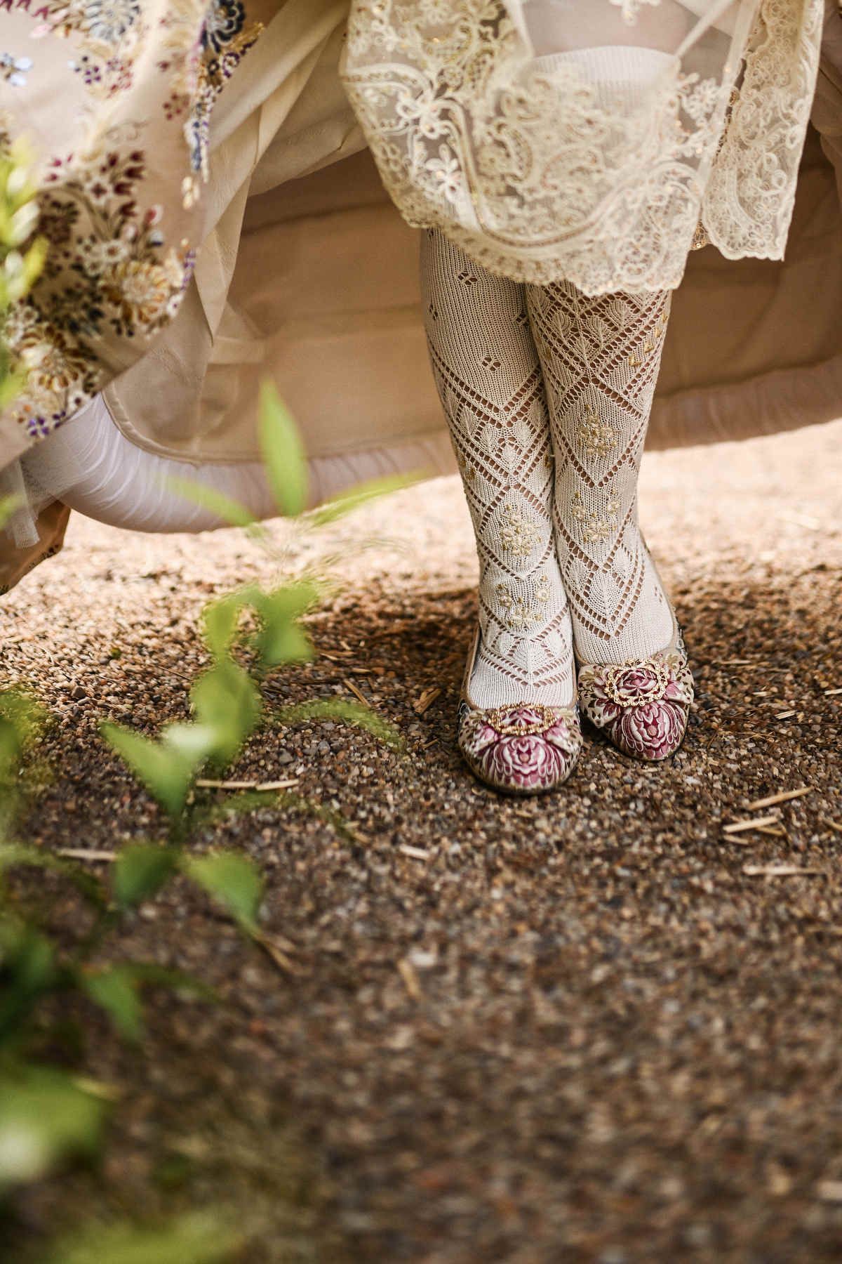 traditional Fallera shoes and intricate embroidered socks (medias bordadas), capturing the artisanal craftsmanship of the Valencian attire.