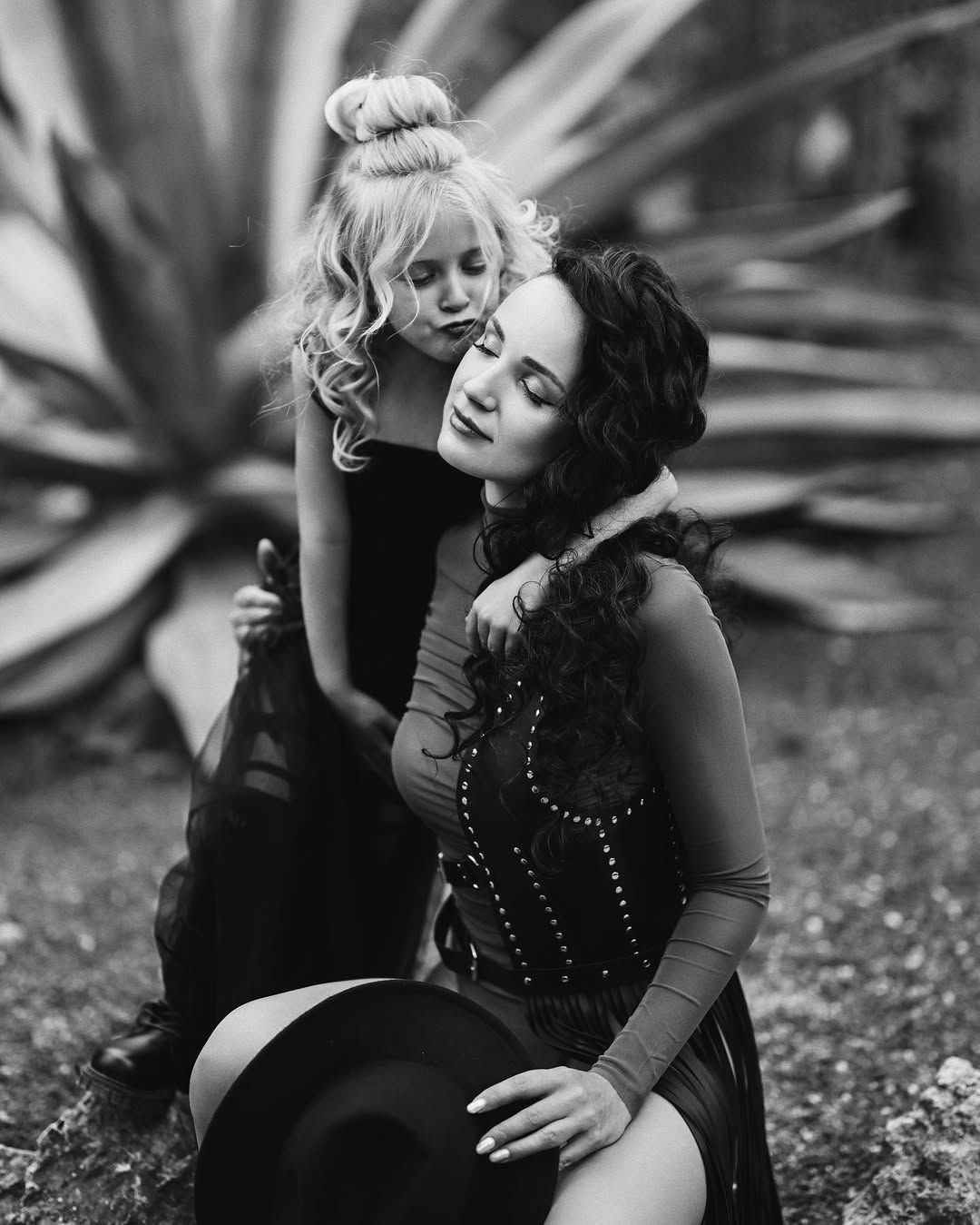 A black and white portrait of a mother and daughter embracing at the Botanical Garden in Valencia.