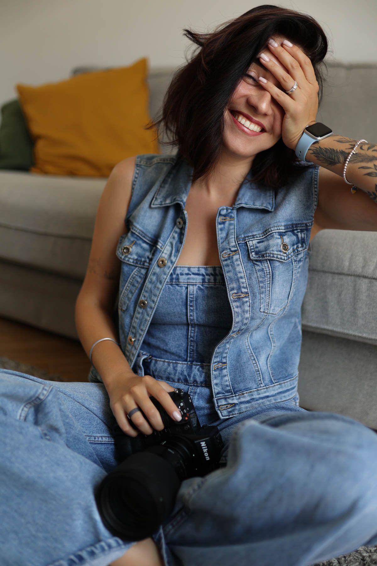 Portrait of fashion photographer Darina Derzkaya laughing and sitting with her camera during a casual studio shoot in Valencia.