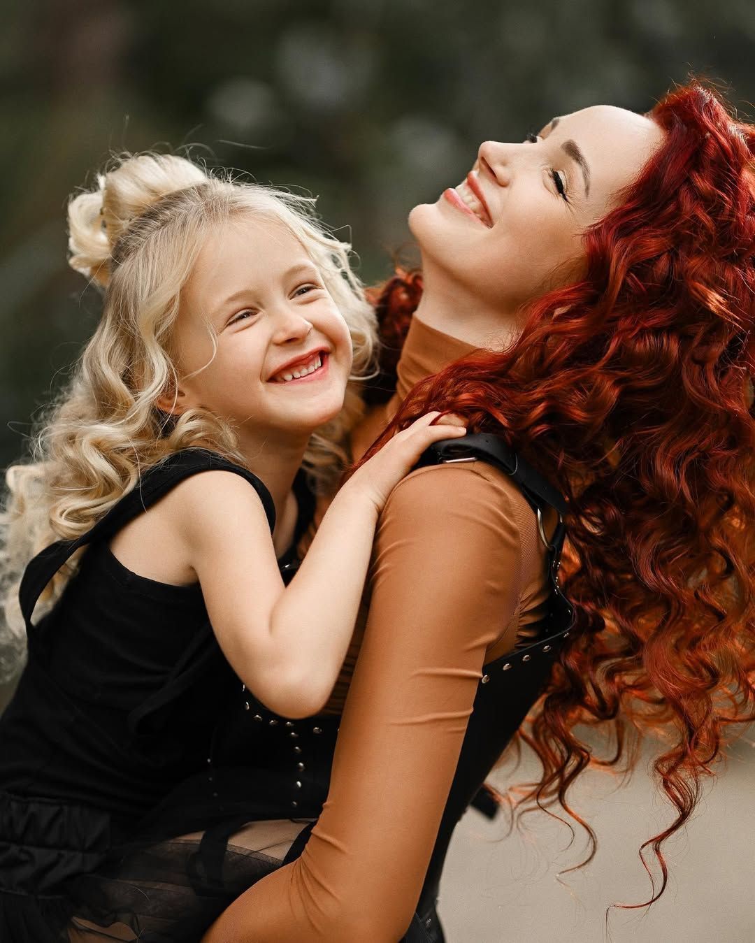 A candid moment of a mother and daughter sharing a joyful hug during their botanical garden photoshoot.