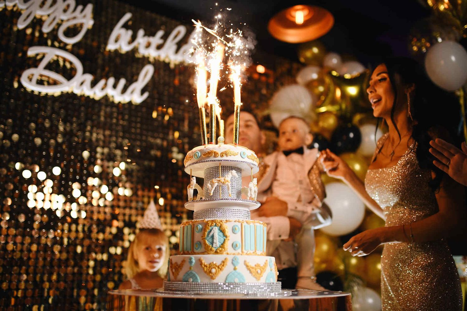 A carousel birthday cake with bright sparkling cold fountains lit up during the final cake presentation of the event.