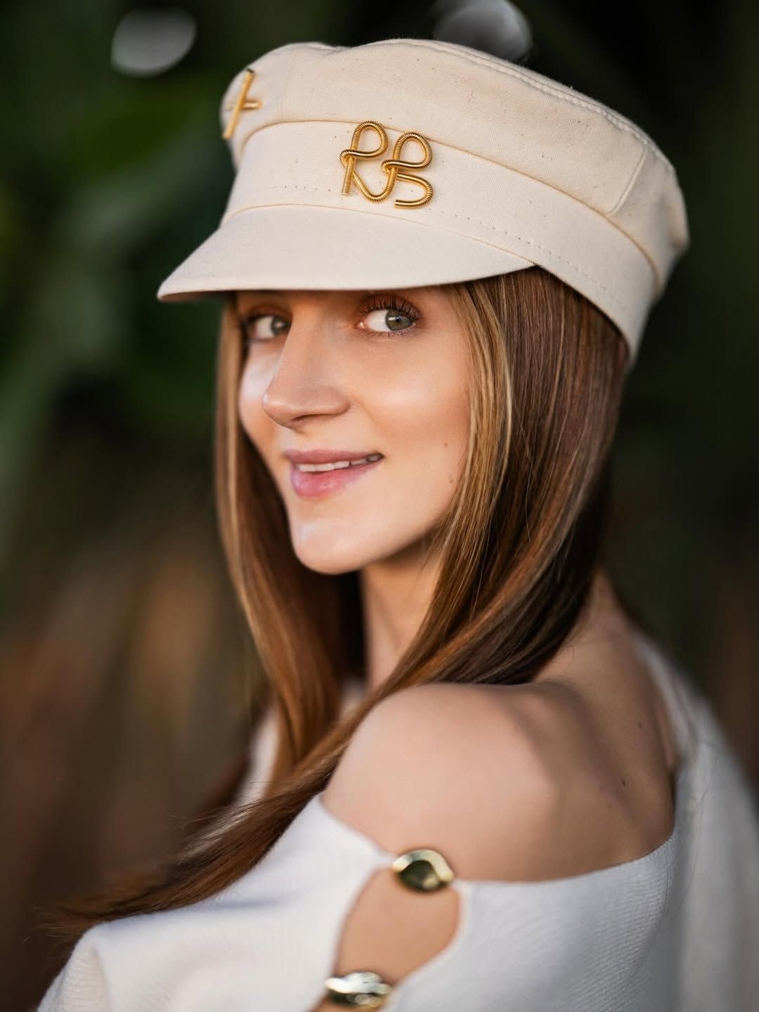 Woman looking over her shoulder against tropical greenery during a sunny photoshoot in Valencia