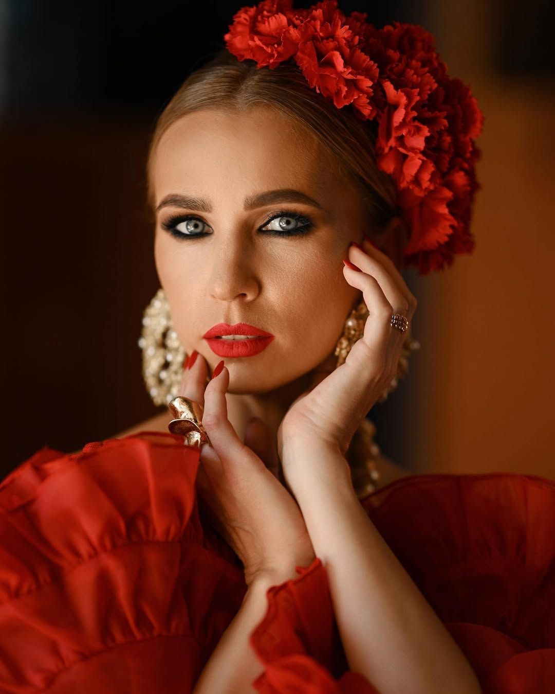 High-fashion portrait of a woman with bold red lipstick and elegant styling looking into the camera at Villa Montemolar