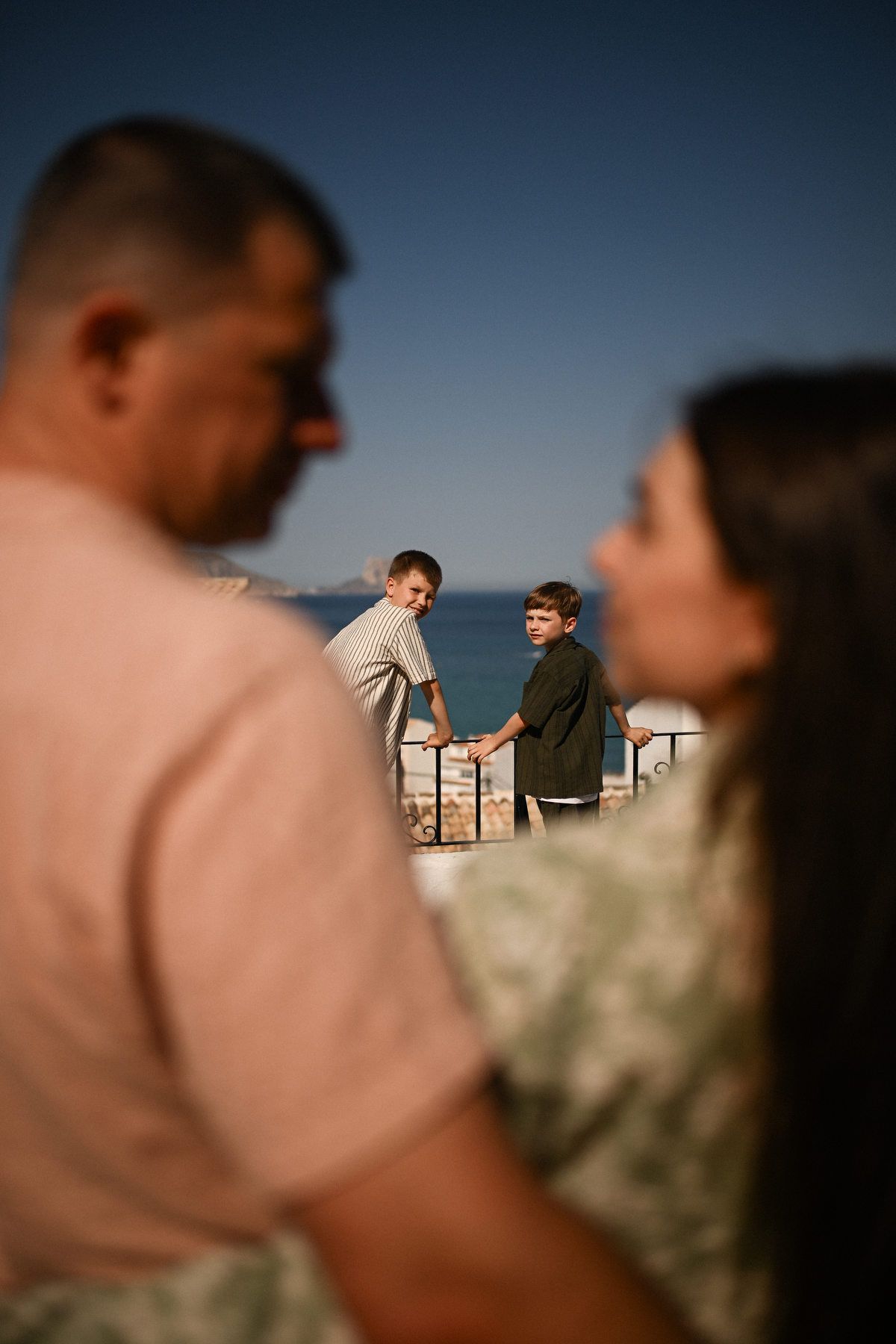 Two boys looking over the coastal edge during a documentary-style family photoshoot on the hills of Altea.