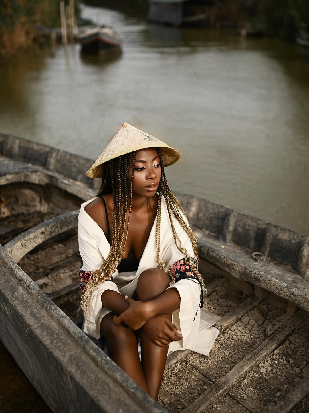 Unstaged and natural portrait photography of a woman relaxed, hugging her knees inside a wooden boat in Albufera
