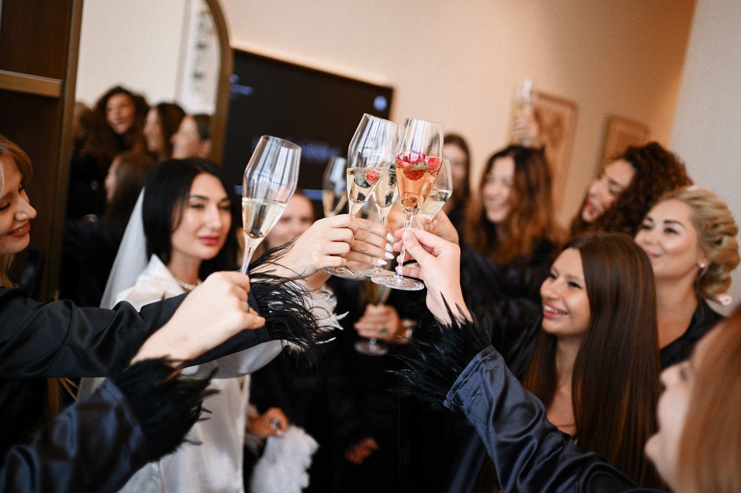 Hen weekend celebration in Valencia, showing a close-up of bridesmaids in black pajamas toasting with champagne glasses.