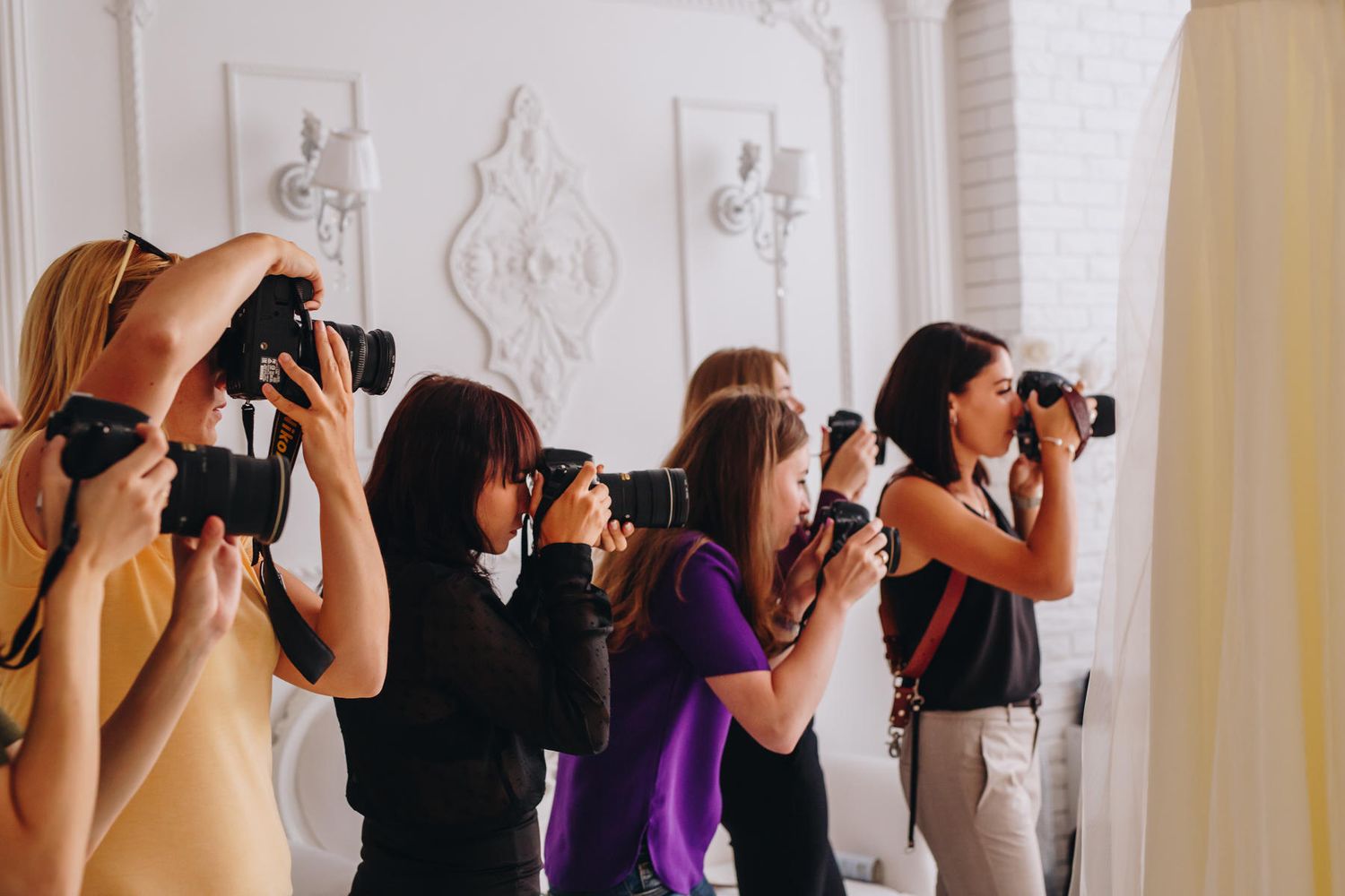 Practical photography mastermind session where a group of female photographers are actively shooting with their cameras.