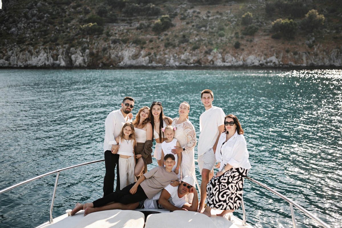 Large group photo of family and friends celebrating a destination gender reveal party on the deck of a yacht in Costa Blanca.