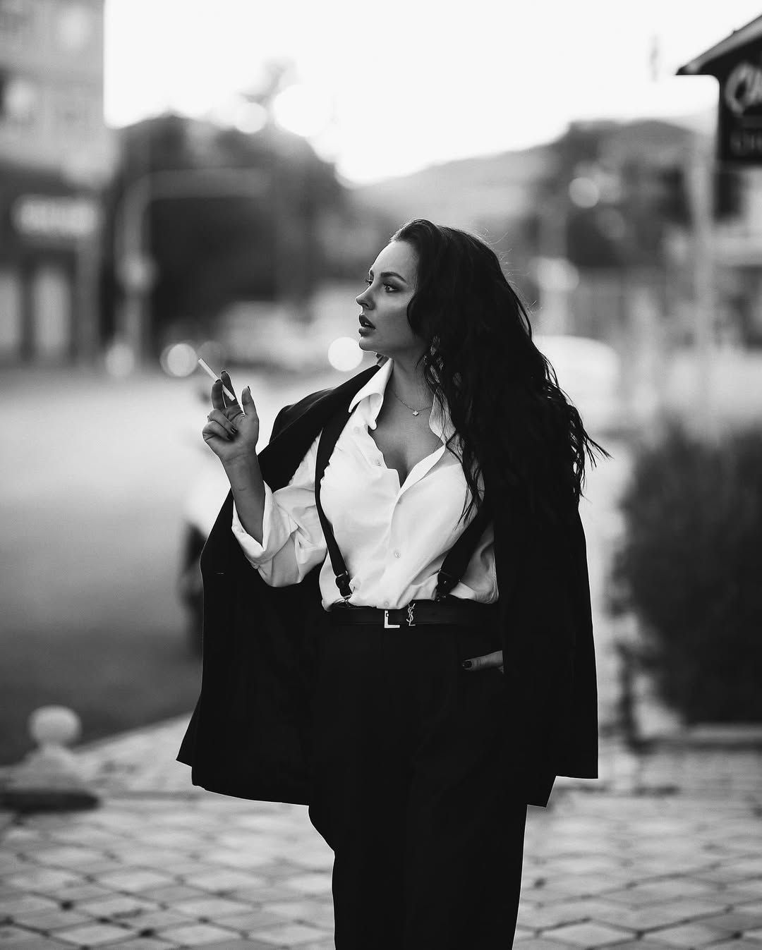 A powerful monochrome editorial shot of a woman in a suit walking confidently, exemplifying professional urban fashion photography.