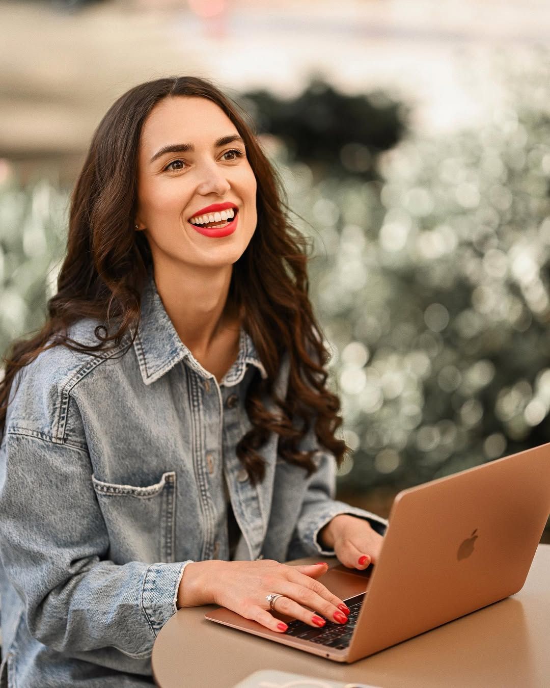 Happy freelancer typing on a laptop during a personal branding photoshoot at a coffee shop in Valencia