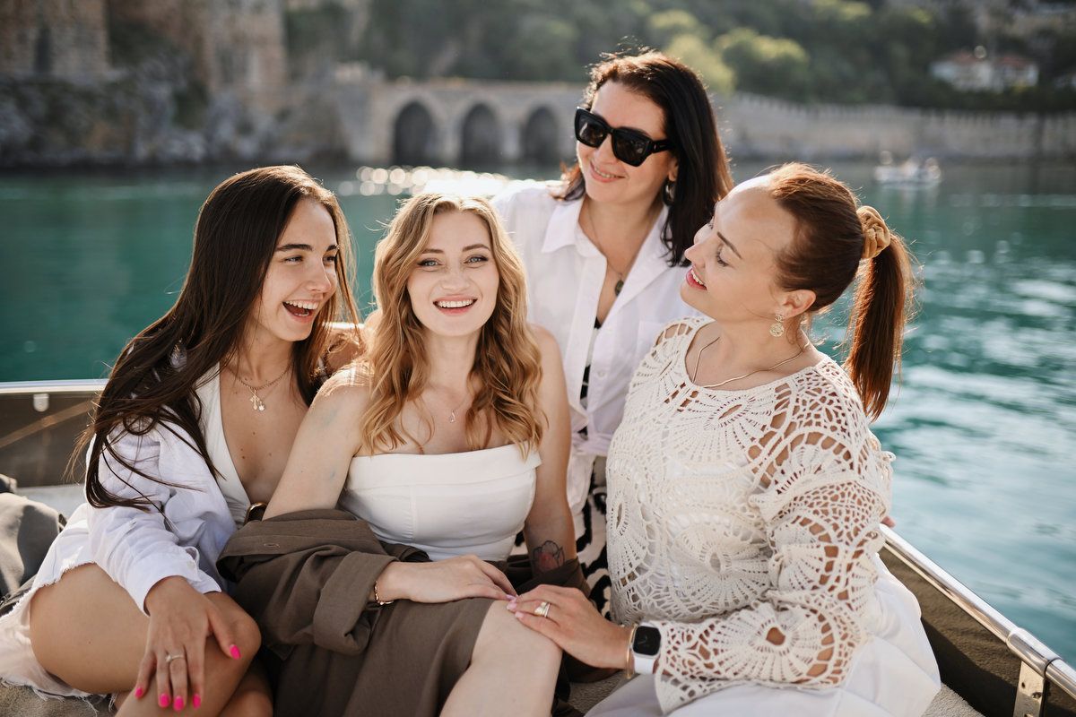 Pregnant woman laughing with her closest friends during a beautiful baby shower and gender reveal celebration on a yacht.