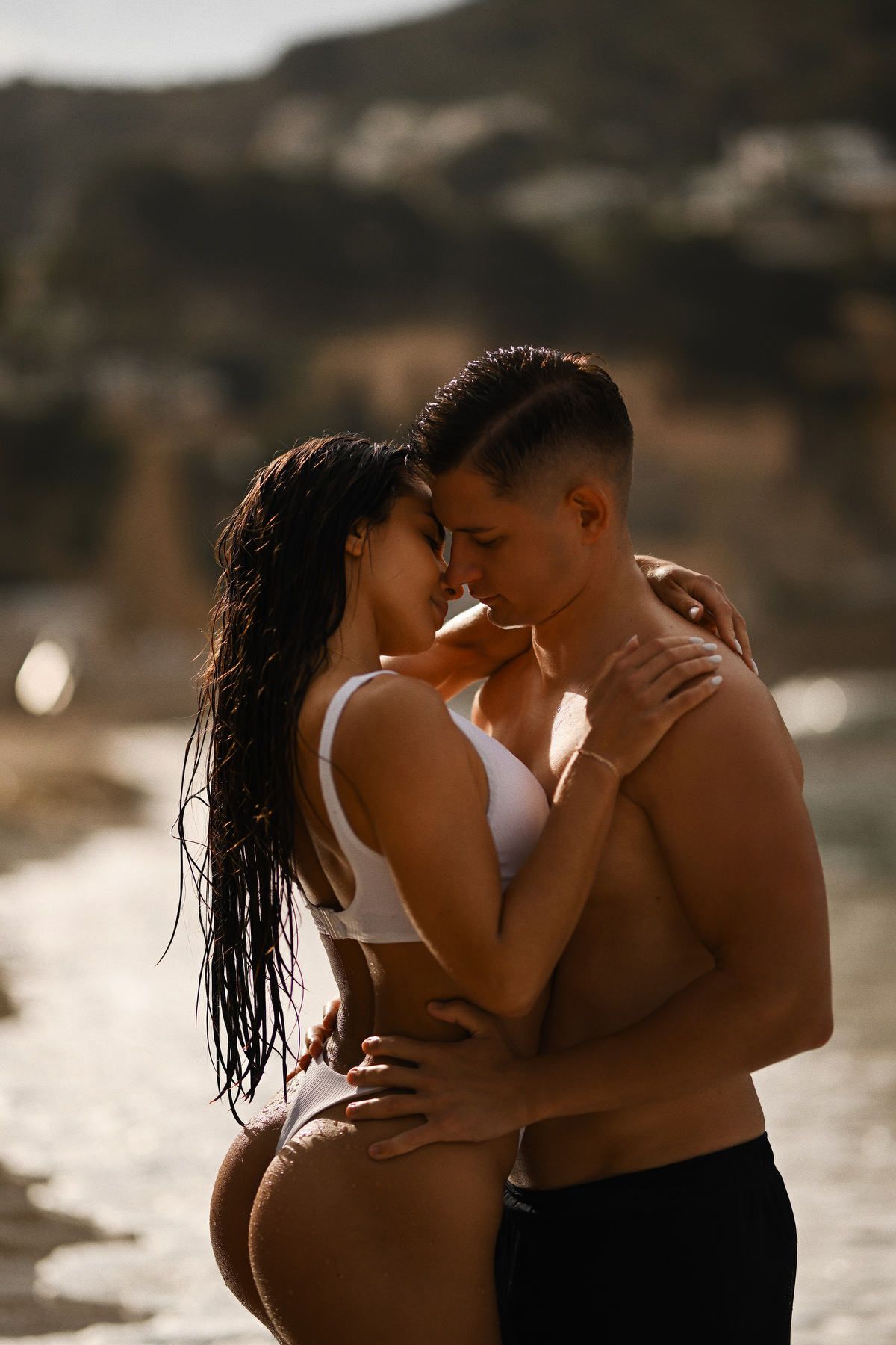 Intimate portrait of a couple embracing in the shallow waters of the Costa Blanca during a sunset photoshoot