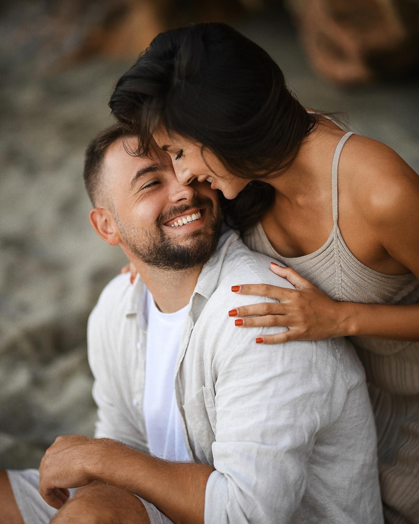 A joyful close-up portrait of a laughing couple enjoying their honeymoon session, glowing in the warm Mediterranean light of Valencia.