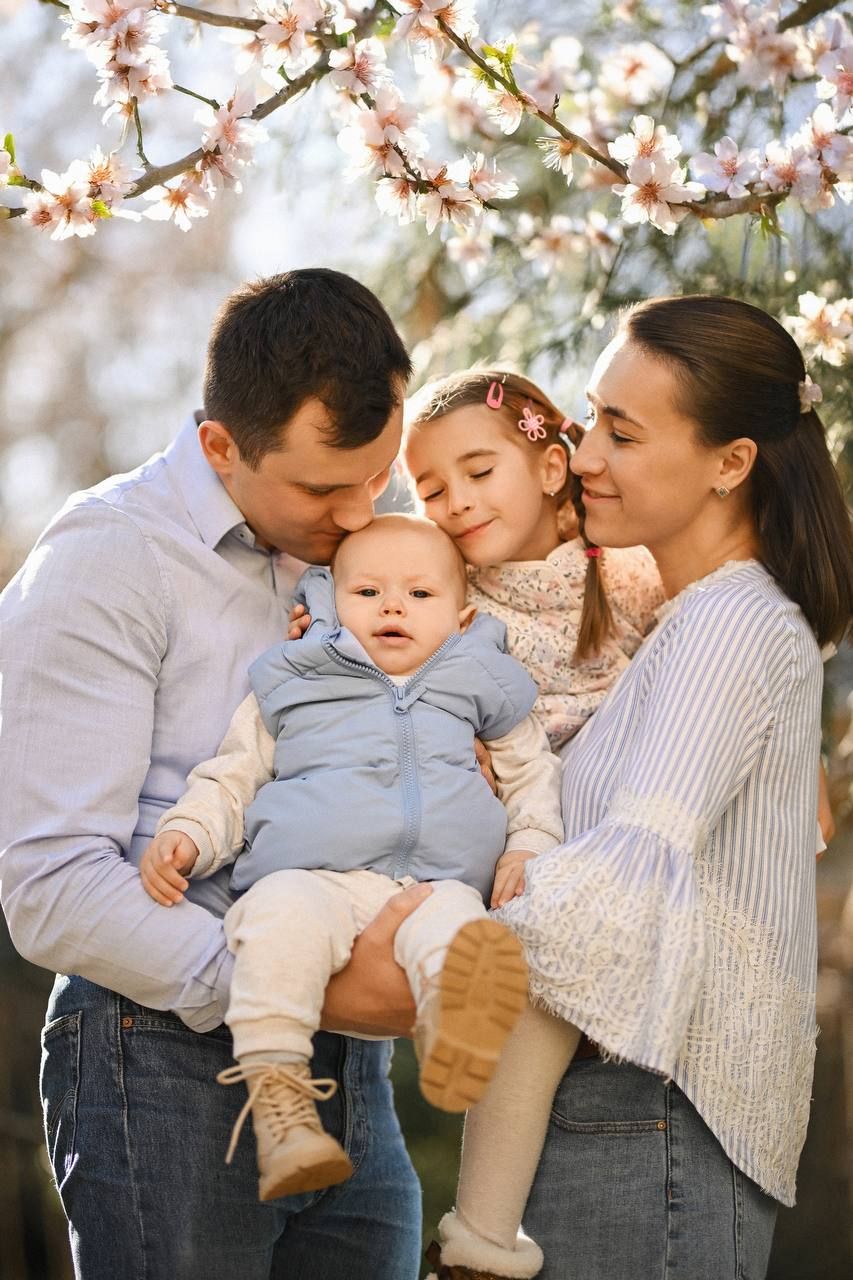 A joyful family walking together in a sunny park, showcasing a client review for a relaxed, documentary-style family photoshoot in Valencia.
