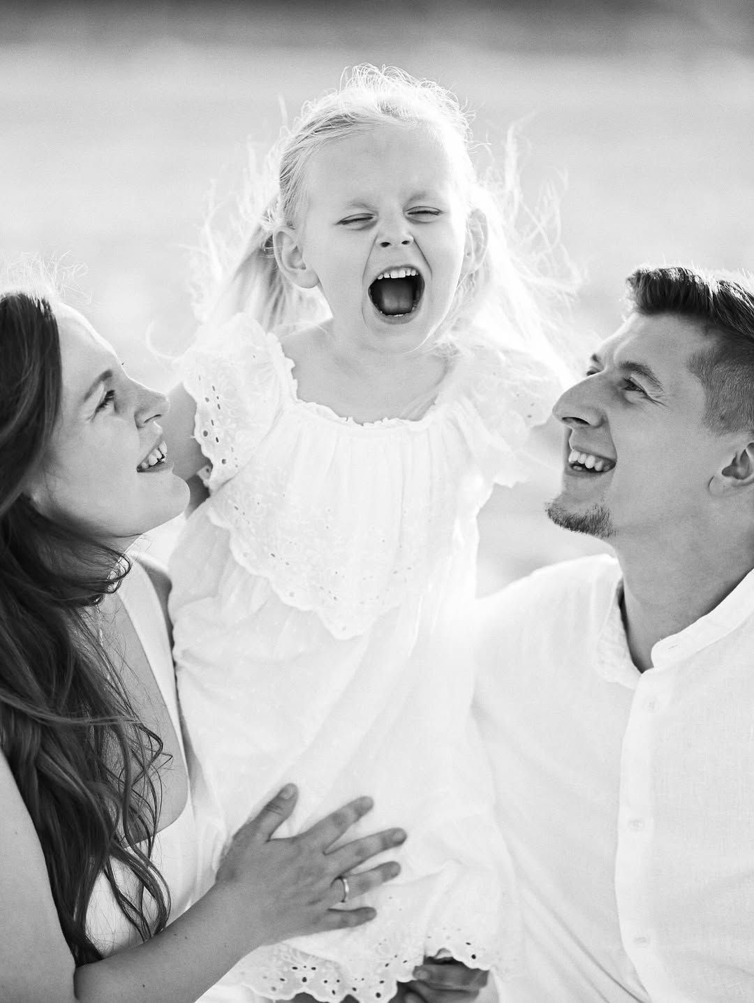 A candid black and white close-up of a family laughing together during their natural outdoor photoshoot in El Saler.