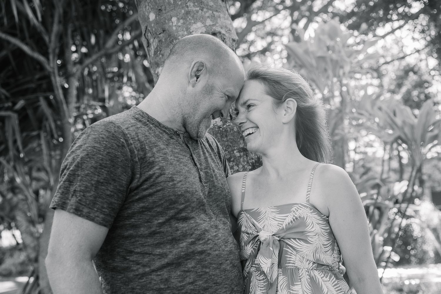 A couple shares tender moments in a black and white photo series outdoors.