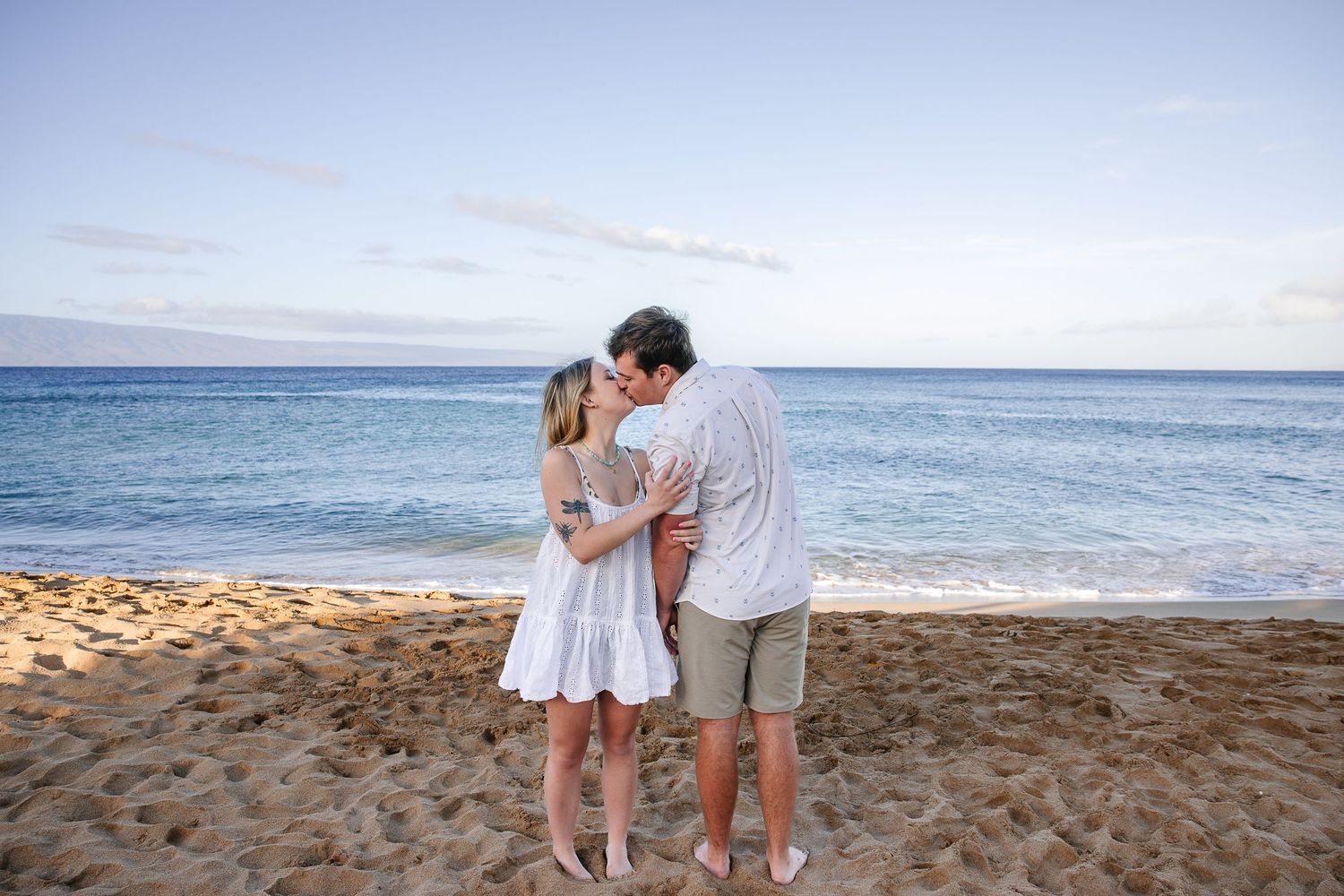 Family group enjoying a beach photoshoot at sunset with ocean backdrop.