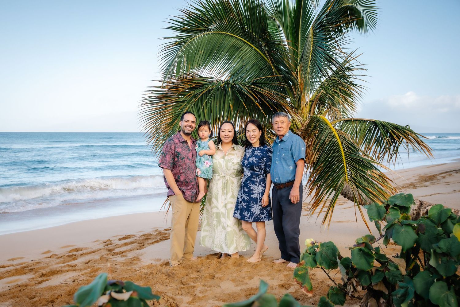 A tropical beach wedding ceremony setup with palm trees and ocean waves in the background.