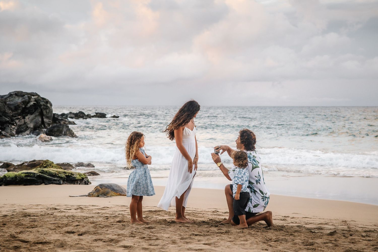 Family photoshoot sequence on a sandy beach with ocean waves in the background.