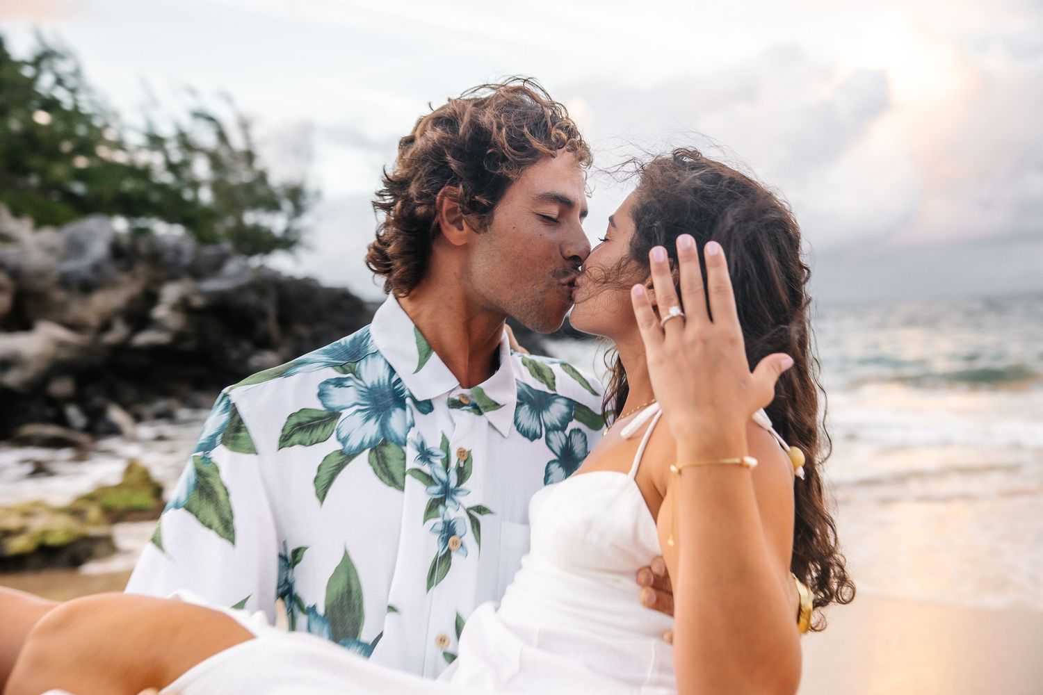 Romantic sunset beach portraits with couple sharing intimate moments by the ocean.