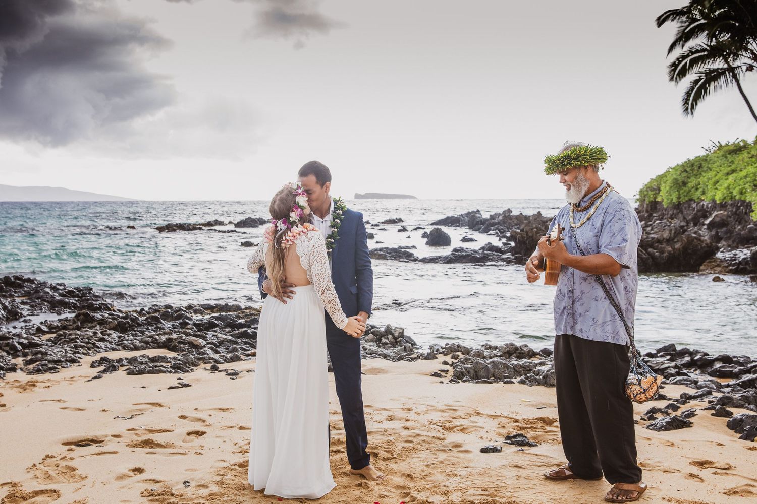 A beachside wedding ceremony with traditional Hawaiian elements and ocean backdrop.