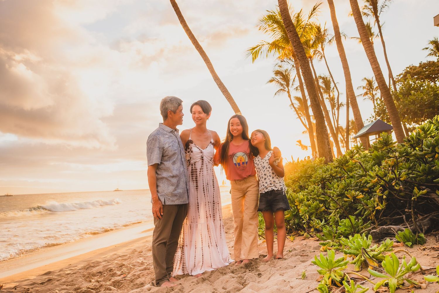 A family gathering on a tropical beach at sunset with palm trees swaying in the background.