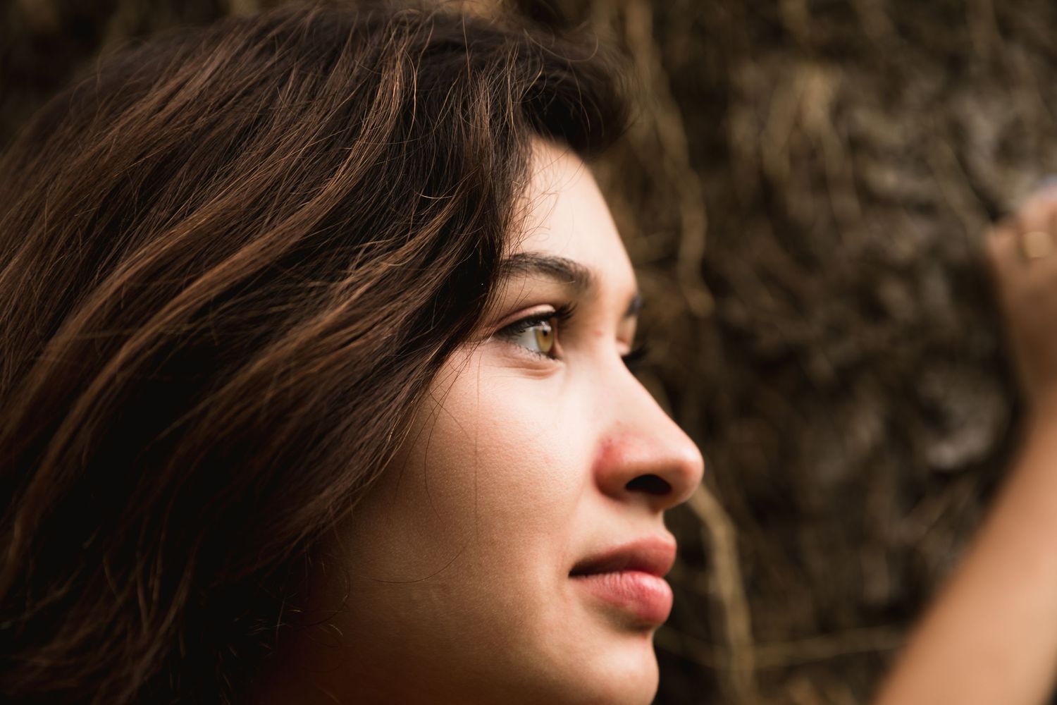 Close up portrait of a pregnant woman in natural lighting against a dark background.