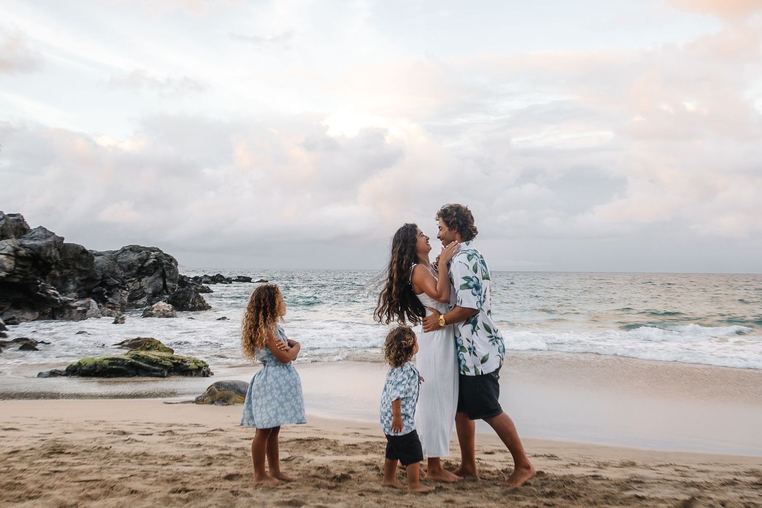 Beach engagement photography session with couple enjoying romantic moments by the ocean.