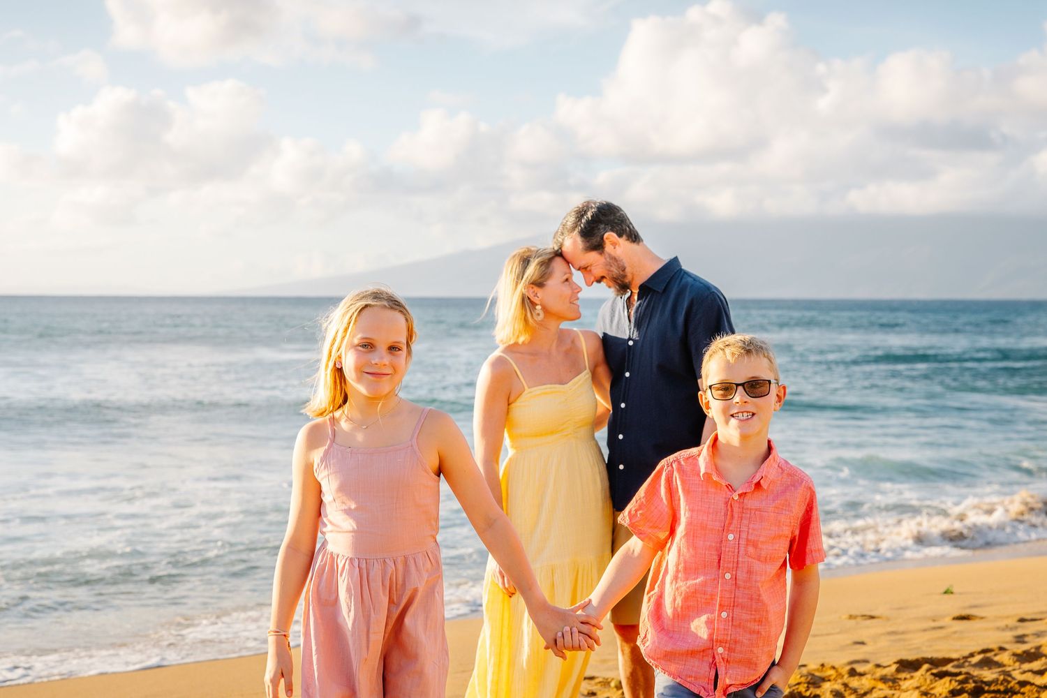 Beachside portrait session with people wearing coordinated pastel and blue outfits.