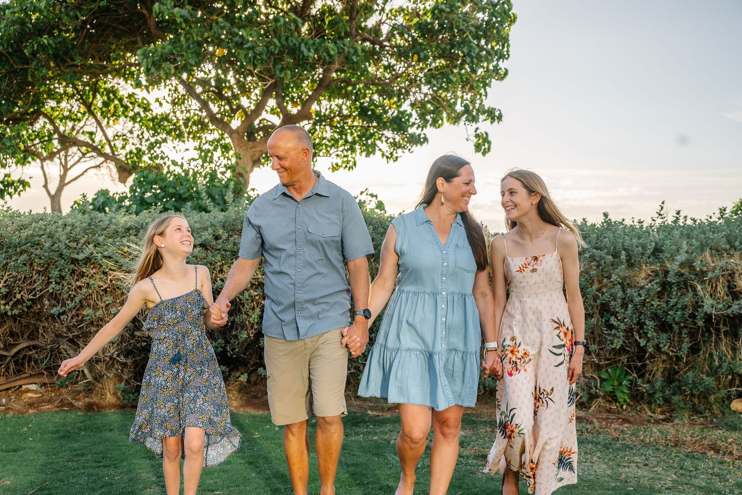 Family walking together and laughing during casual outdoor photo session.