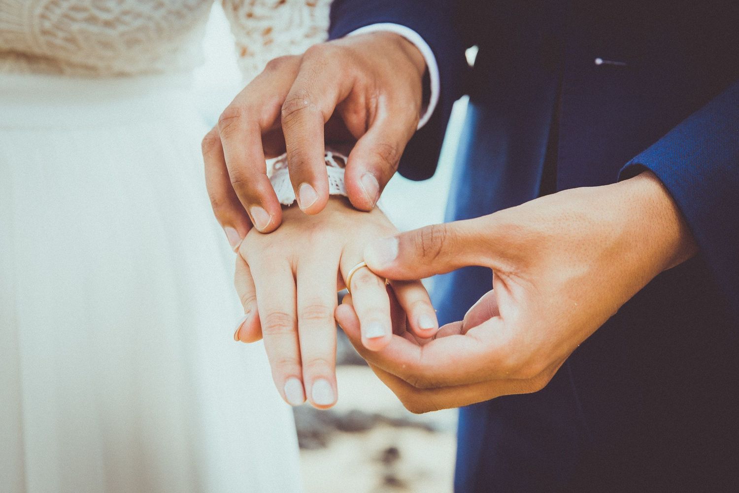 Close-up of wedding ring exchange during an intimate ceremony moment.